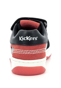 Zapatilla negra y roja con materiales de ante y cuero, la vista trasera muestra el logo, costuras contrastantes y una suela de goma blanca.