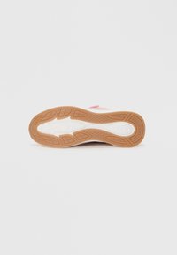 Λευκή σόλα αθλητικού παπουτσιού με υφή από καουτσούκ χρώματος τσίχλας, με λευκή μεσαία σόλα, ροζ λεπτομέρειες και σχεδιασμό με χαμηλό προφίλ.