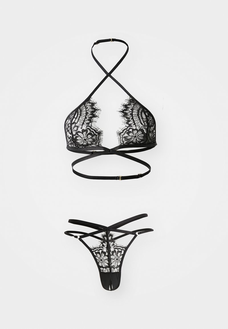 Sort blondelingeri-sæt med en trekantet bralette med krydsede stropper og en matchende tanga med et blomstermønster i blondestof.