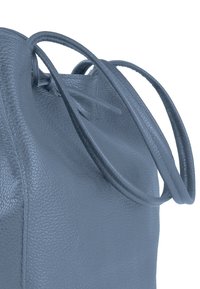 Sac en cuir bleu avec une surface texturée, doté de poignées longues et fines ainsi que d'une ouverture resserrée pour la fermeture.