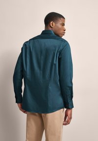 Türkises Hemd mit Knöpfen, glatter Textur, langen Ärmeln und einem stilvollen Kragen. Verfügt über Knöpfe an den Manschetten und ein gerades Rückendesign.