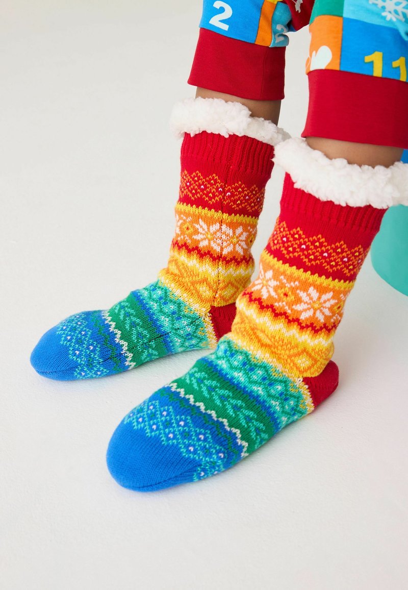 Stricksocken mit einem Rot-, Gelb- und Blaufarbschema. Verfügt über einen flauschigen weißen Saum und komplizierte mehrfarbige Muster entlang der gesamten Länge.