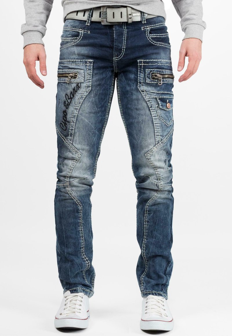 Jeans in denim blu con un finish sbiadito, tasche con cerniera e cuciture a contrasto. Presentano testo ricamato e una vestibilità dritta.