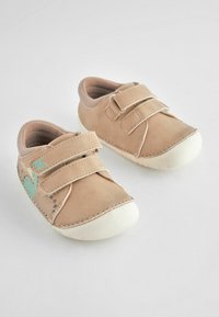 Chaussures en cuir tan avec deux bandes Velcro, semelles en caoutchouc blanches et un design turquoise sur le côté. Texture douce, forme de bout rond.