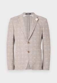 Strukturierter hellbeiger Blazer mit zwei Knöpfen, Reverskragen, Fronttaschen und einer dekorativen weißen Brosche am linken Revers.