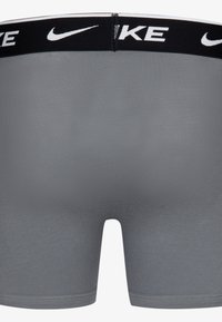 Grå mænds boxer briefs med en glat tekstur, sort elastisk linning med hvidt "NIKE"-logo og en tætsiddende pasform.