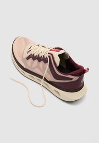 Chaussure de course rose clair et bordeaux avec lacets ouverts, tige en mesh et semelle coussinée sur un fond clair uni.