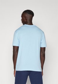 T-shirt in cotone azzurro chiaro con scollatura rotonda e maniche corte, caratterizzato da una vestibilità comoda e una texture liscia. Design semplice, senza motivi.