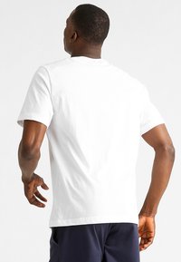 Witte katoen t-shirt met korte mouwen, ronde halslijn en een ontspannen pasvorm. Eenvoudig ontwerp, gladde textuur zonder zichtbare patronen of graphics.