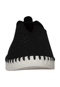 Schwarzer Slipper mit durchbrochenem Design, weißer Gummisohle und dekorativer Naht entlang der Kante. Geeignet für legere Kleidung.