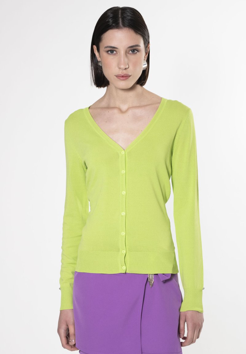 Cardigan verde lime con scollo a V, maniche lunghe e chiusura con bottoni, realizzato in materiale morbido e leggero. Texture liscia, design aderente.