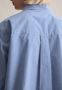 Blauw-wit geruit overhemd met knopen, voorzien van een klassieke kraag, geplooide achterkant en een gladde textuur, gemaakt van een lichtgewicht geweven stof.