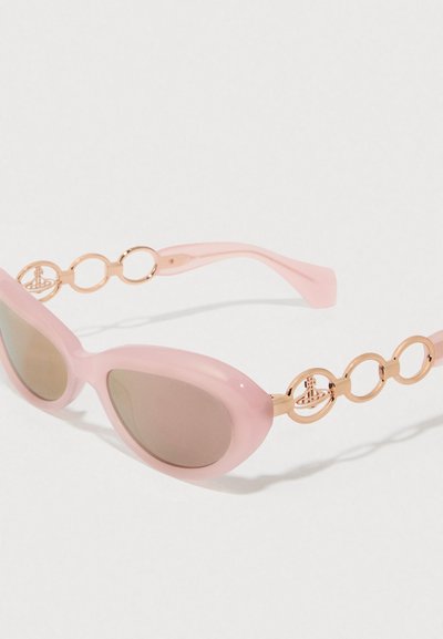Ροζ πλαστικά γυαλιά ηλίου με σχήμα γατιού. Διαθέτουν χρυσές κυκλικές λεπτομέρειες στους βραχίονες και καφέ φακούς με κλίση.