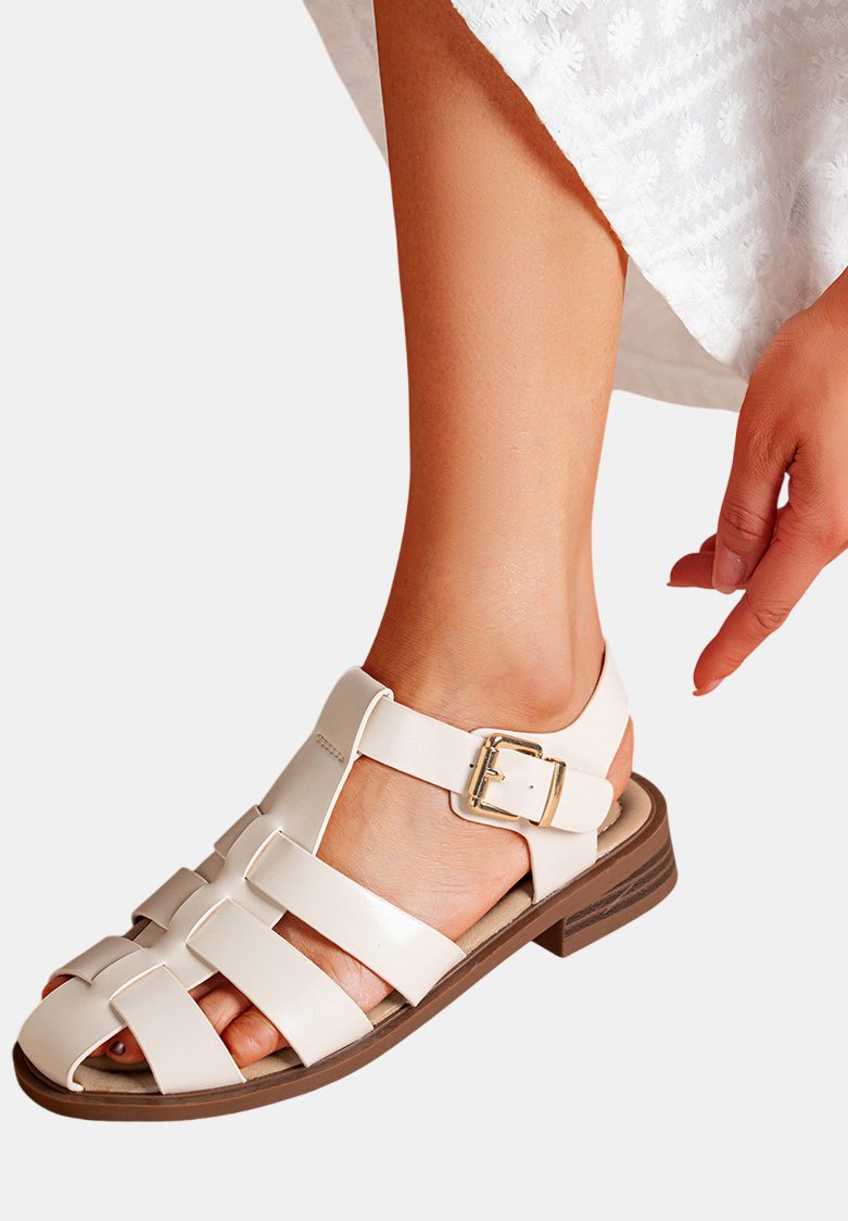 Sandales en cuir blanc avec un design à bout ouvert, dotées de larges brides, de quincaillerie dorée et d'un petit talon bloc marron.