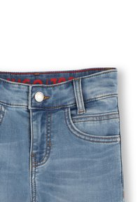 Vaqueros de mezclilla azul claro con cierre de botón, costuras en contraste de color naranja y etiqueta de marca roja en la cintura. Textura suave y diseño clásico de cinco bolsillos.