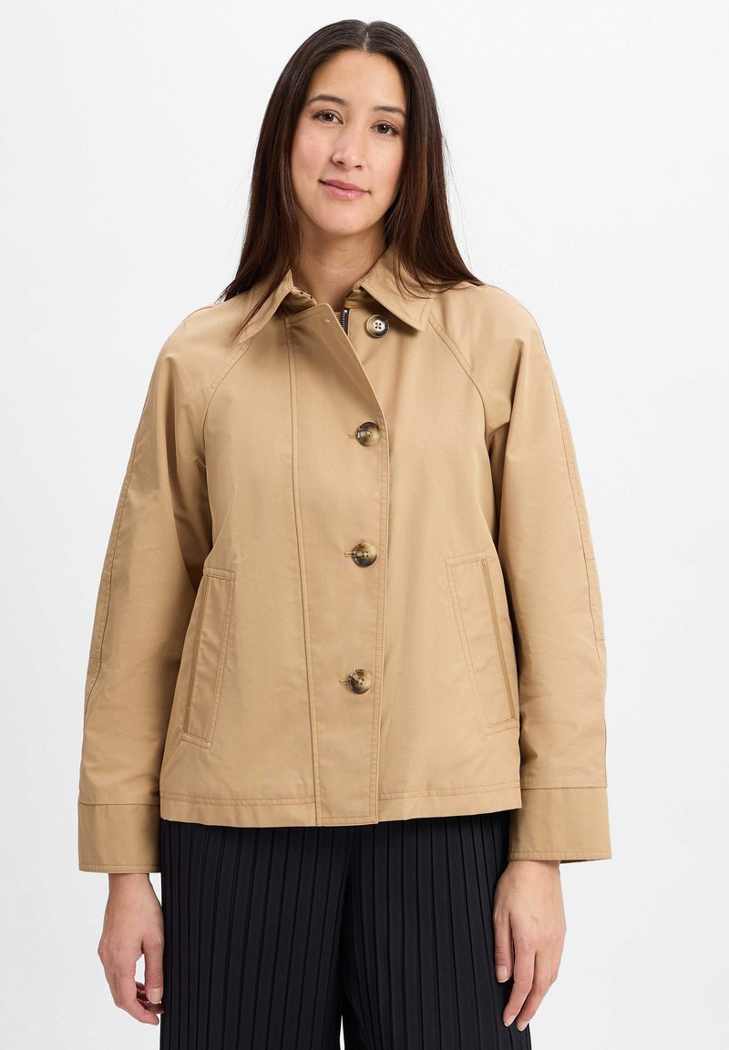 Beige, leichtgewichtige Jacke mit Kragen, fünf Knöpfen und zwei Seitentaschen. Besitzt einen geraden Schnitt und eine glatte Textur.