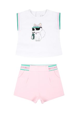 Top bianco senza maniche con grafica di un gatto con occhiali da sole e visiera abbinato a pantaloni corti rosa chiaro con cintura a righe verdi e rosa.