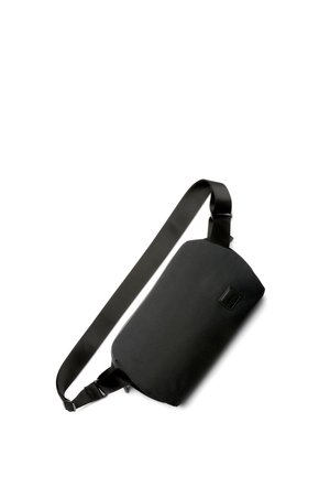 Black sling bag made from durable fabric. Rectangular shape with a satin strap and a small logo detail. Smooth texture, minimalistic design.