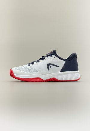 Scarpa da ginnastica atletica bianca, blu navy e rossa con punta testurizzata, logo nero sul lato e suola spessa progettata per presa e supporto.