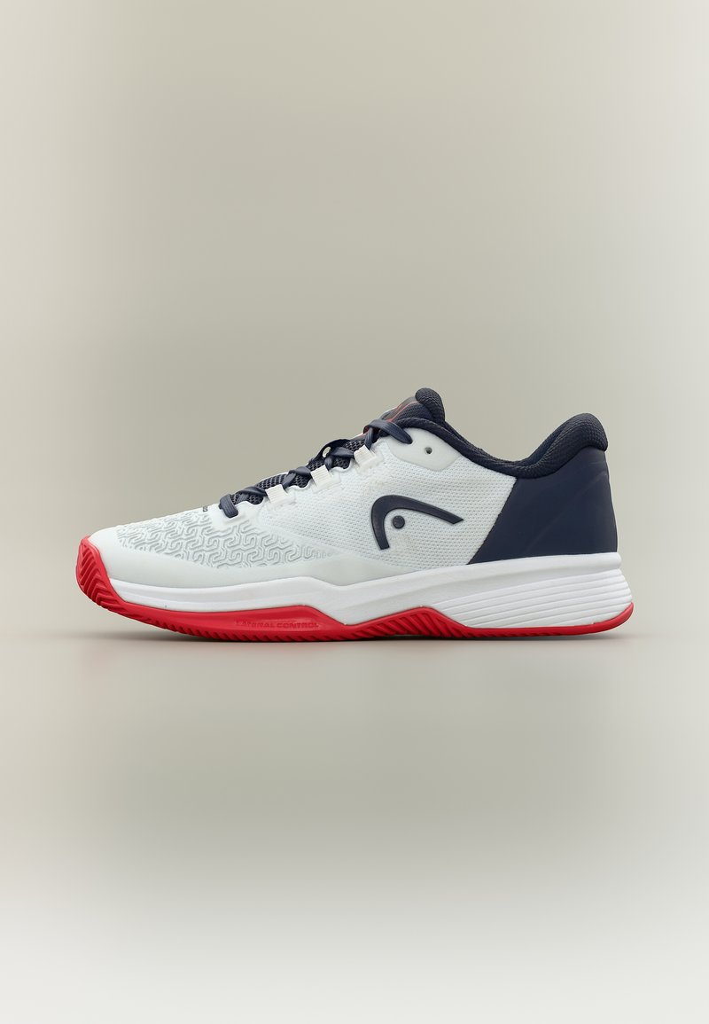 Weißer, marineblauer und roter Sportschuh mit strukturierter Spitze, schwarzem Logo an der Seite und dicker Sohle, die für Grip und Unterstützung entwickelt wurde.