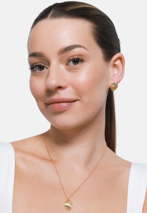 Gull smykker med ribbet skjellformede øredobber og en matchende pendant halskjede, som fremhever glatt tekstur og shiny finish.