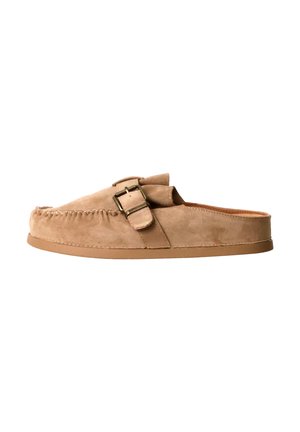 Mocassins en daim couleur tan à enfiler avec boucle latérale et semelle plate basse, sans talon pour un port facile.