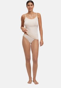 Camisole beige in cotone con spalline sottili e scollo arrotondato, abbinata a mutandine a vita bassa dello stesso colore. Tessuto liscio, design aderente.