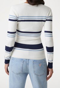 Suéter a rayas con franjas horizontales en azul marino, azul claro y blanco, hecho de tela suave con un diseño ajustado y puños acanalados.