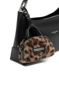 Sac à épaule en cuir noir avec un petit pochette en peluche imprimée léopard marron et noir, ornée d'accents dorés et de la marque.