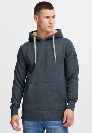 Dark gray hoodie with a textured inner lining, adjustable drawstrings, and front pocket. Features a logo patch on the left sleeve.