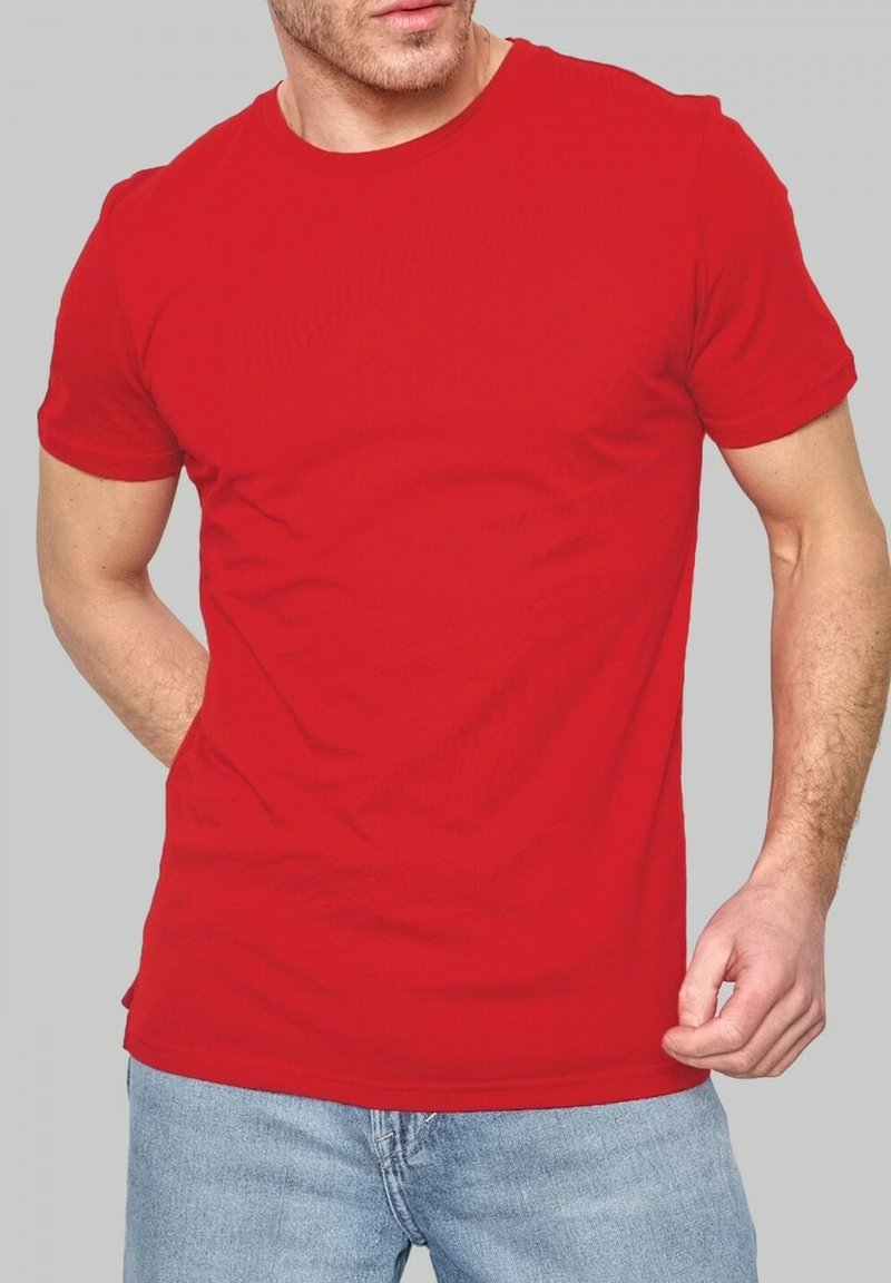 T-shirt en coton rouge avec un col rond et des manches courtes, arborant un design simple et une silhouette ajustée, associé à un jean bleu.