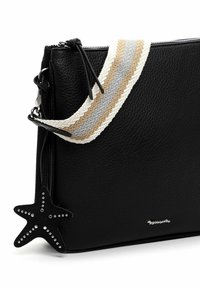 Black textured leather crossbody bag with beige, gray, and white striped strap and black star-shaped studded zipper pull charm.