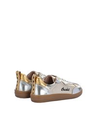 Sneakers in beige chiaro, pelle metallizzata argento e oro, con un design a lacci, punta rotonda e suola in gomma marrone con branding.