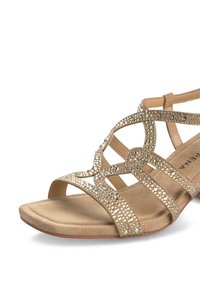 Sandali beige con più cinturini caratterizzati da inserti in strass e una suola piatta e imbottita. Tessuto liscio e design aperto.