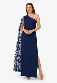Marineblauwe jurk met een schouderontwerp, heeft een bloem-lace overlay die van de schouder hangt en een hoge split tot aan de dij. Soepele textuur.