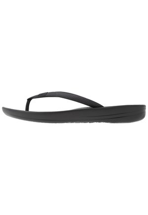 Tongs noires avec une lanière texturée, une semelle rembourrée et un design épuré et minimaliste. Convient pour un usage décontracté.
