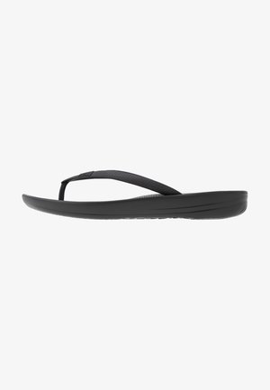 Black flip-flop featuring a textured strap, a cushioned sole, and a sleek, minimalistic design. Suitable for casual wear.