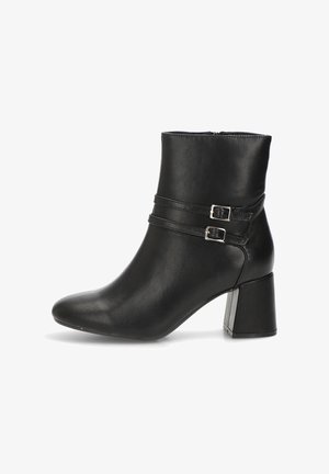 Bota de cuero negro hasta el tobillo con punta puntiaguda, tacón cuadrado y dos correas con hebilla alrededor del tobillo. Textura lisa y diseño elegante.