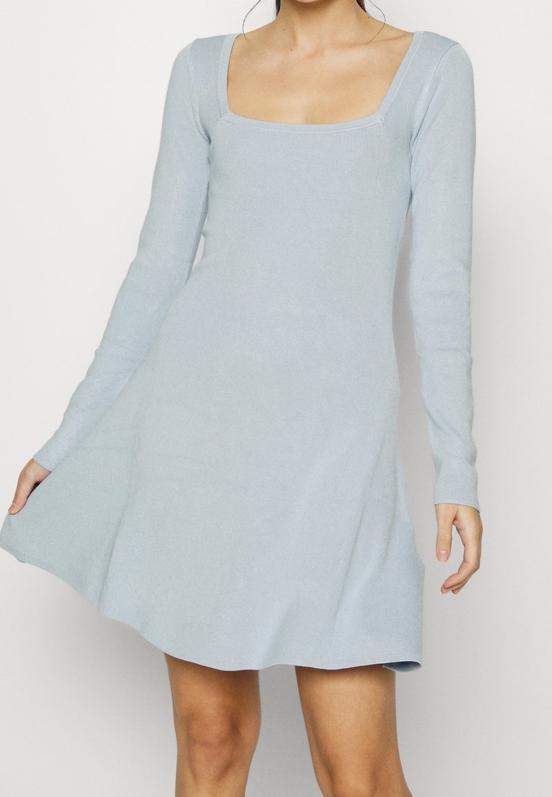 Robe longue à manches longues bleu clair avec un décolleté carré, un corsage ajusté et une jupe évasée, fabriquée à partir d'un tissu doux et côtelé.