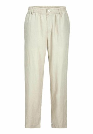 Beige overhemd met korte mouwen en een gestructureerde afwerking, met knopen aan de voorkant, gecombineerd met lichtgekleurde broek en zwart-witte sneakers.