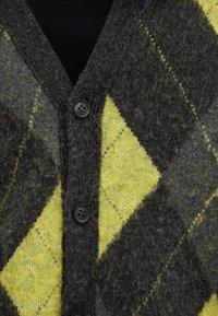 Cardigan argyle grigio e giallo in misto lana; presenta un collo a V, sei bottoni neri e una leggera texture con fibre visibili.