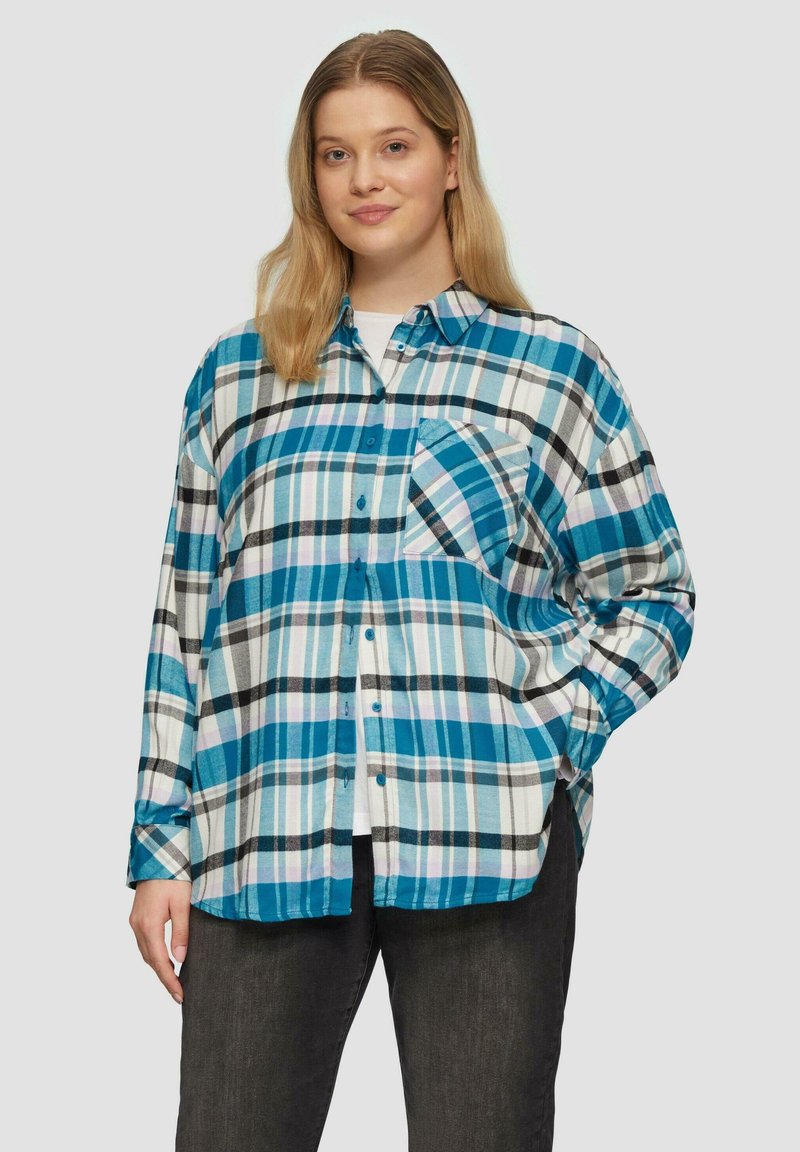Camicia in flanella blu, nera e bianca a quadri. Presenta una chiusura con bottoni, colletto e taschino sul petto. Tessuto leggero.