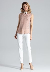 Lichtroze mouwloze blouse met een witte kraag, voorzien van een subtiel vogelpatroon, gecombineerd met witte rechte broek en naakte hoge hakken.