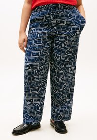 Παντελόνια σε σκούρο μπλε με λευκά αφηρημένα σχέδια, κατασκευασμένα από ελαφρύ υλικό, με κορδόνι στη μέση και πλαϊνές τσέπες.