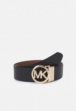 Ceinture en cuir noir enroulée avec une boucle circulaire dorée portant les initiales "MK" sur fond blanc.