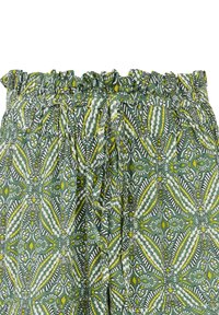Shorts en tissu vert avec une taille volante, ornés d'un motif floral en jaune, blanc et vert foncé. Lien à l'avant.