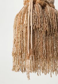 Beaded fringe in shades of gold and beige, made from small glass beads. Features a textured, flowing design with a ribbon tie at the top.