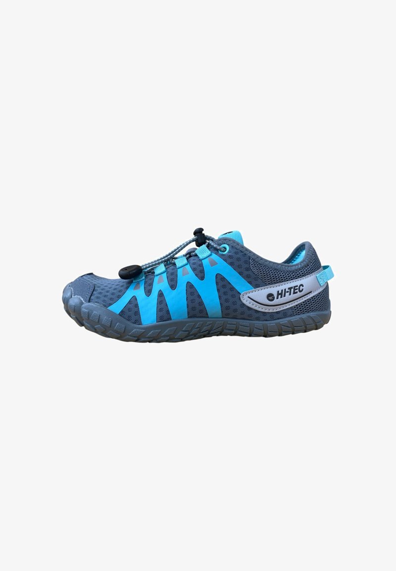 Zapatilla deportiva gris con acentos azules, parte superior de malla y sistema de lazada elástica. Presenta una suela de goma texturizada para agarre y flexibilidad.