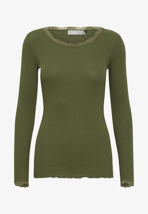 Hosszú ujjú, bordázott póló olívazöld színben, fodros csipke nyakkivágással és csipke díszítéssel a mandzsettán. Puha textúra és testhezálló dizájn.
