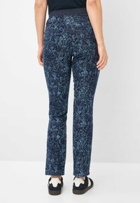 Marineblauwe broek met een bloemenpatroon in lichtere tinten, voorzien van een rekbare tailleband, rechte pijpen en achterzakken.